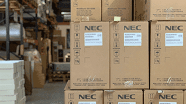 NEC boxes stacked up in a warehouse